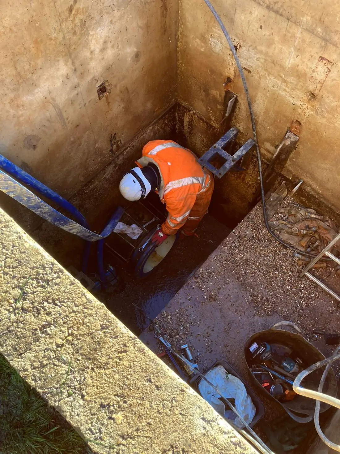 Cascade Water Services engineer accessing an underground chamber during a utility survey