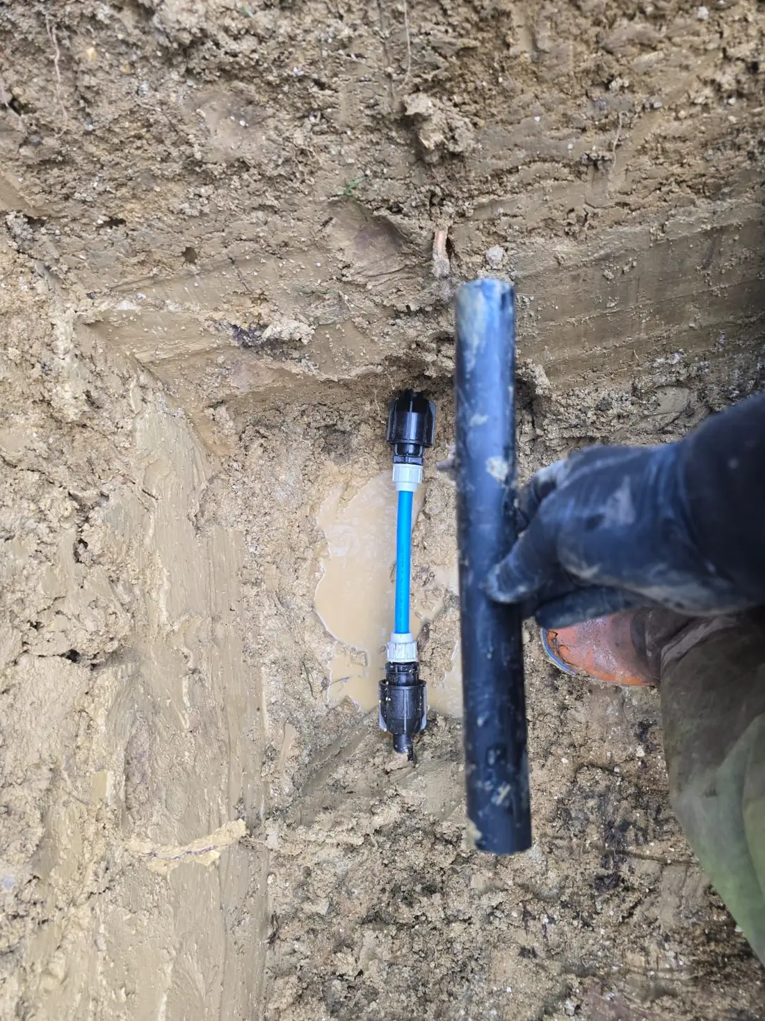 Section of old supply pipe cut out and replaced with new blue MDPE